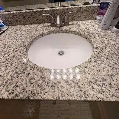 A sparkling granite bathroom sink after a deep clean