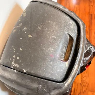 A grimy, paint-splattered trash can before cleaning