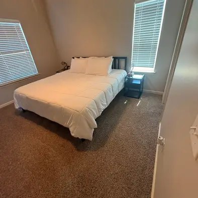 A freshly made bed in a cleaned bedroom