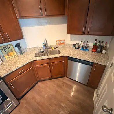A cleaned kitchen with granite counters and stainless appliances
